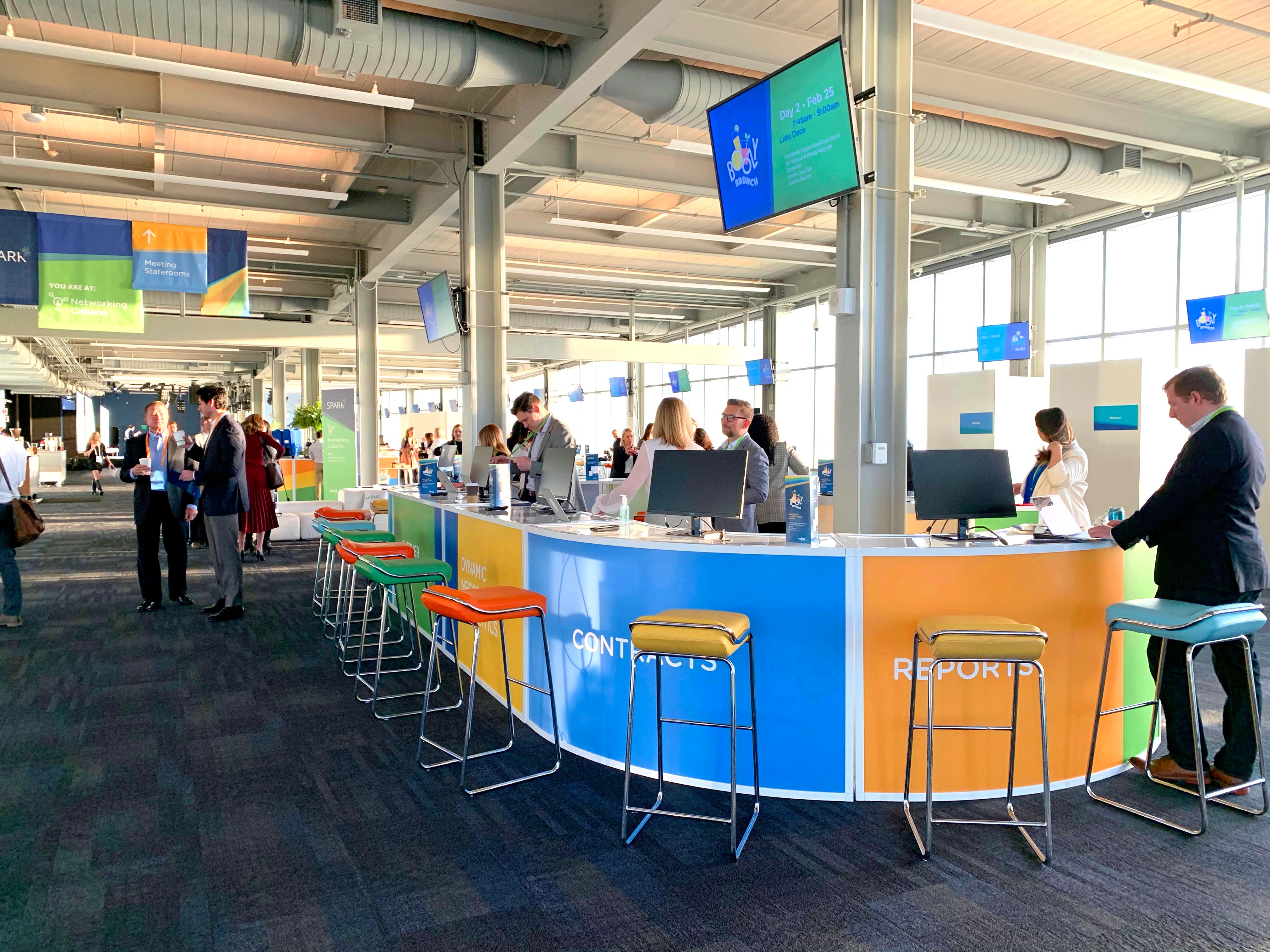 Networking and demo counter at the Spark Customer Event with attendees and employees